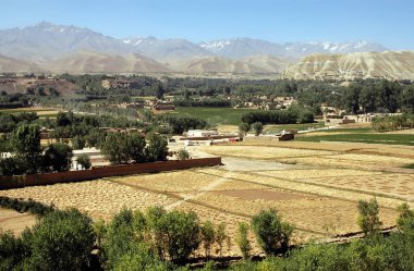 Orta Afganistan 'da Bamyan (Bamiyan). Kasabayı, ağaçları, tarlaları ve karlı dağları gösteren Bamyan (Bamiyan) Vadisi üzerinde bir manzara. Kasaba Afganistan 'ın ünlü UNESCO Buda' larına ev sahipliği yapar.