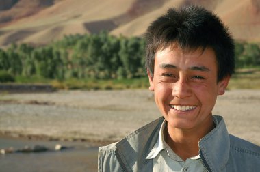 Yakawlang, Bamyan (Bamiyan), Afganistan. Orta Afganistan 'ın Yakawlang kasabasında gülümseyen Afgan bir çocuk. Geniş tebessümlü mutlu bir Afgan..