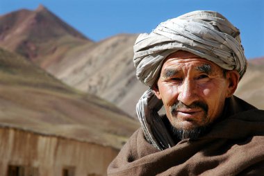 Bamyan (Bamiyan) ilindeki Syadara (Siyah Darah), Afganistan. Orta Afganistan 'ın küçük Syadara kasabasında yaşayan bir Afgan. Sarıklı ve sakallı bir adam dağ zemininde.