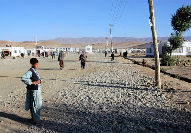 Ghor Eyaleti, Afganistan 'daki Chaghcharan. Orta Afganistan 'ın ücra bir köşesindeki en büyük şehirlerden biri olan Chaghcharan' ın ana caddesi. Yolda duran bir çocukla yerel hayat sahnesi.