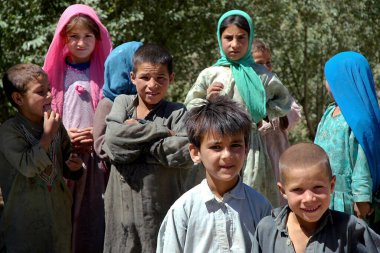 Afganistan 'ın Ghor Eyaleti' ndeki Jam Minaresi yakınlarında göçebe yerleşimi. Çocuklar geleneksel kıyafetler giyerek poz verirler. Orta Afganistan 'ın bu ücra köşelerinde göçebeler hala yaygın..