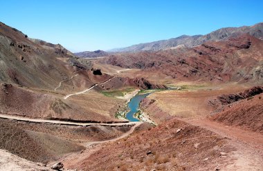 Afganistan 'ın Herat ilindeki Chisht-e-Sharif yakınlarındaki Hari Nehri (Harirud). Nehir, Batı Afganistan 'ın bu ücra köşesindeki bir yol eşliğinde renkli bir dağ manzarasından akıyor..