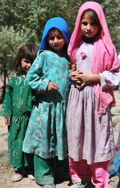 Nomad settlement near the Minaret of Jam, Ghor Province in Afghanistan. Children pose wearing traditional clothes. Nomads are still common in this remote part of Central Afghanistan. clipart