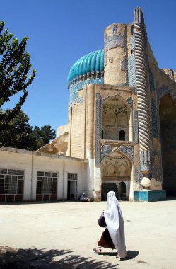 Afganistan 'ın Balkh kentindeki Khwaja Abu Nasr Parsa Tapınağı' nda (Yeşil Cami) beyaz çarşaflı bir kadın. Tapınak mozaikler ve biçimlendirilmiş Kuran el yazısıyla süslenmiş. Afganistan 'daki camii