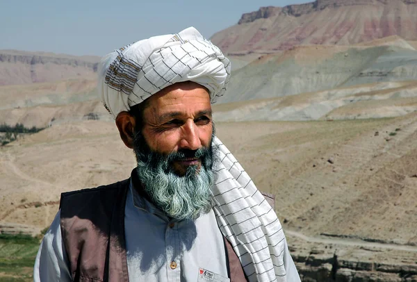 Herat ve Qala-e-Naw arasındaki köy, Herat Eyaleti, Afganistan. Afganistan 'ın batısının ücra bir köşesinde, dağ manzaralı türban takan yerel bir Afgan..