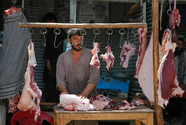 阿富汗巴尔赫省巴尔赫 在阿富汗北部巴尔赫 一位传统的屠夫在自己的商店里准备肉 阿富汗当地一家肉铺的钩上挂着生红的肉 — 图库照片