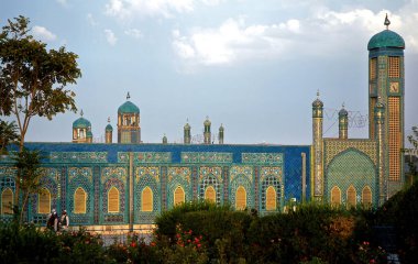 Mazar-i-Şerif, Balkh Eyaleti, Afganistan. Mazar i Sharif 'teki Mavi Cami' nin bahçesi. Bazı insanlar gün ışığından hoşlanır. Renkli mozaikler ve fayanslar caminin duvarlarını süslüyor. Kuzey Afganistan.