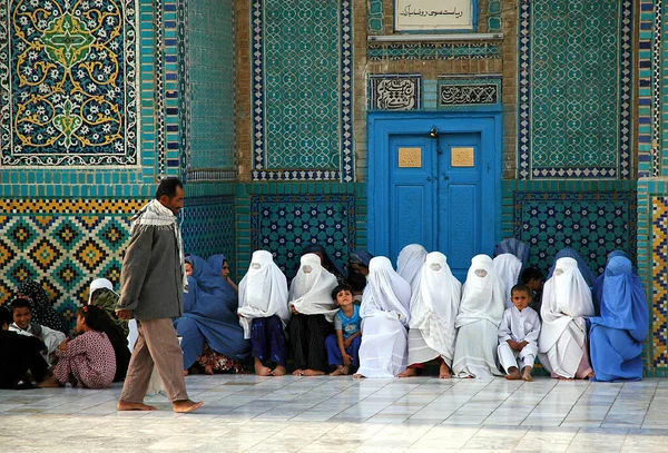 Balkh Eyaleti, Afganistan 'daki Mazar-i-Şerif. Bir erkek geçerken, Mazar i Sharif 'teki Mavi Cami' nin önünde mavi ve beyaz çarşaf giyen Afgan kadınlar bekliyor. Kuzey Afganistan