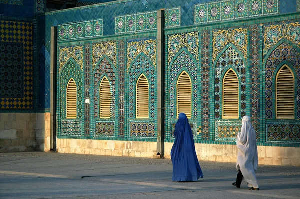 阿富汗巴尔赫省马扎里沙里夫的蓝色清真寺 两名身穿Burqas Burkas 的妇女走过清真寺墙壁 墙上装饰着五彩斑斓的瓷砖和镶嵌画 阿富汗北部 — 图库照片