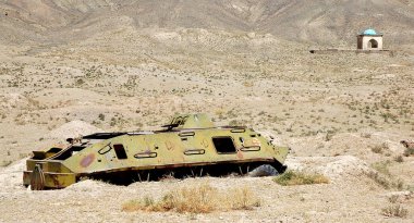 Ghazni in Ghazni Province, Afghanistan. A destroyed tank in a field near Ghazni in Afghanistan. This abandoned vehicle is near the Ghazni Minarets and is a reminder of the Afghanistan war. clipart