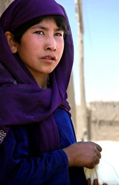Afganistan 'da Gazni. Afganistan 'ın orta kesimindeki Gazni şehrinde yaşayan Afgan bir kız. Kız geleneksel kıyafetler giyiyor. Afganistan 'ın merkezinde, Gazni' de yerel hayat.