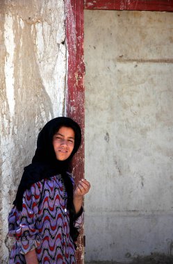 Afganistan 'da Gazni. Afganistan 'ın orta kesimindeki Gazni şehrinde yaşayan Afgan bir kız. Kız geleneksel kıyafetler giyiyor. Afganistan 'ın merkezinde, Gazni' de yerel hayat.