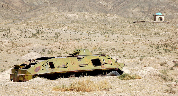 Ghazni in Ghazni Province, Afghanistan. A destroyed tank in a field near Ghazni in Afghanistan. This abandoned vehicle is near the Ghazni Minarets and is a reminder of the Afghanistan war.