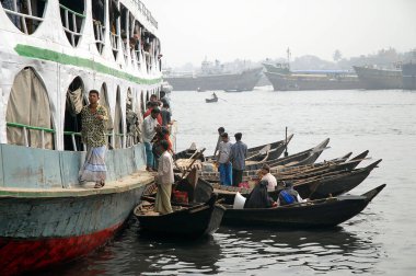 Bangladeş, Dhaka 'da Sadarghat. Dhaka 'daki Sadarghat nehrinde bir geminin yanında demirlemiş küçük tekneler. Yerel ulaşım Bangladeş tarzı.