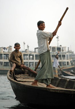 Bangladeş, Dhaka 'da Sadarghat. Dhaka 'da Sadarghat' ta küçük bir teknede iki çocuk. Bangladeş 'te birçok yerli insan nehri bu şekilde geçer..