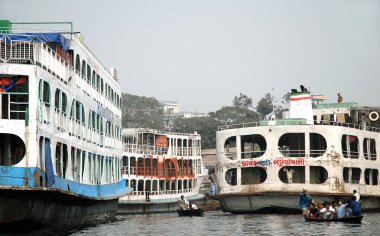 Bangladeş, Dhaka 'da Sadarghat. Küçük teknelerle Dhaka 'daki Sadarghat' tan geçen yerel halk büyük gemiler arasında yol alıyorlar. Sadarghat Bangladeş 'te büyük bir limandır..