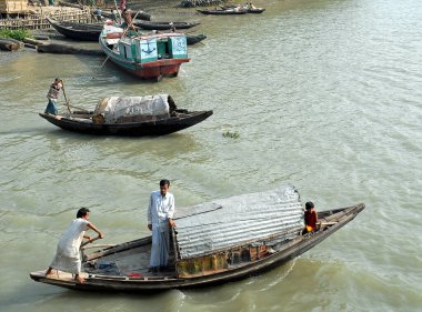 Bangladeş 'teki Ganj Deltası. Küçük bir kasabanın yakınındaki nehirde kürek çeken balıkçı tekneleri. Güney Bangladeş 'te Ganj Deltası' nın su yolları.