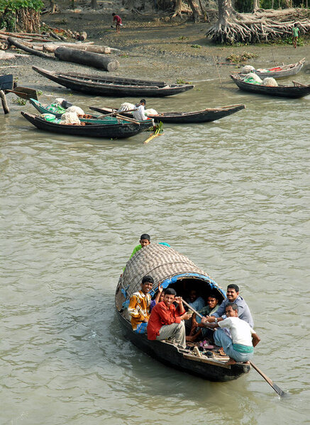 The Ganges Delta in Bangladesh. A group of men on a small boat on the river in the Ganges Delta. Waterways of the Ganges Delta in southern Bangladesh.