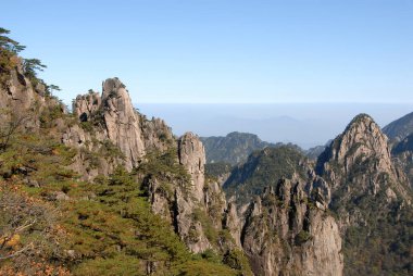 Huangshan Dağı, Anhui Eyaleti, Çin. Huangshan 'ın Beyaz Kaz Tepesi' ndeki kayalık tepelerinin güzel panoramik dağ manzarası. Çin 'deki Huangshan Dağı' nın zirvesine yakın bir yerden..
