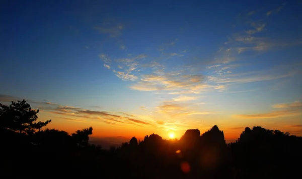 黄山安徽省 中国で 山のカラフルな空 雲やシルエットで黄山の上の日の出 レンズフレアで 中国黄山の頂上付近の日の出 — ストック写真