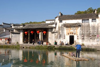 Anhui Eyaleti, Çin 'deki Hongcun Antik Kasabası. Lexu Hall ve Hongcun 'daki Moon Pond' daki eski binalar. Gölette salda bir adam var. Çin 'deki antik Hongcun kasabasının mimarisi..