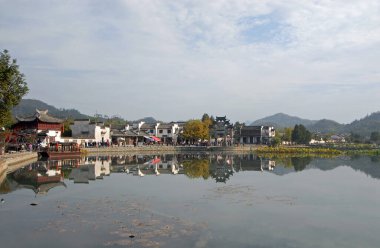 Çin 'in Anhui eyaletindeki Xidi Antik Kasabası. Eski kasabaya giriş ve Ming Jing Gölü boyunca görülen Hu Wenguang anıtı kemer yolu. Çin 'in antik Xidi kasabası. Eski binalar ve geniş göl manzaralı..