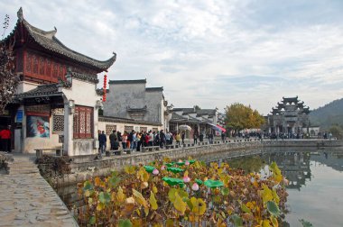 Çin 'in Anhui eyaletindeki Xidi Antik Kasabası. Hu Wenguang anıtı kemer yolu, Ming Jing Gölü ve zambakları olan eski kasabaya giriş. Çin 'in antik Xidi kasabasında eski binalar ve göl