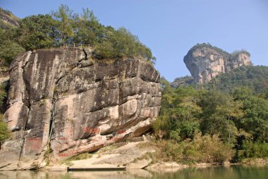 Wuyishan Dağları, Fujian Eyaleti, Çin. Üzerinde yazı olan kayalar ve Nine Bends River veya Nine Twist Stream 'den görünen DaWang (Büyük Kral) Tepesi. Wuyi dağları Çin 'deki UNESCO sahası.