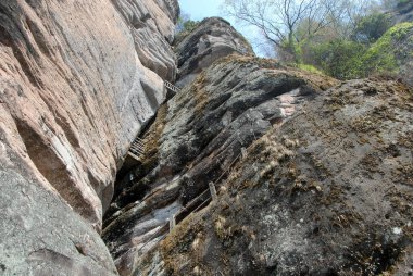 Wuyishan Dağları, Fujian Eyaleti, Çin. DaWang (Büyük Kral) Tepesi yolunda. Dağda dik kayalıklar var ve patika kayanın içindeki çatlağın içinde. Wuyishan, Çin 'de bir UNESCO sitesi..