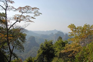 Wuyishan Dağları, Fujian Eyaleti, Çin. DaWang (Büyük Kral) Tepesi yolunda. Önünde ağaçlar olan tepeleri ve dağları seyret. Wuyishan, Çin 'de bir UNESCO sitesi..