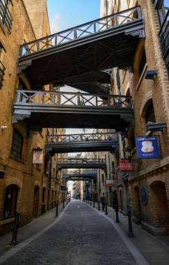 Londra, İngiltere 'den Shad Thames. Londra 'da Tower Bridge yakınlarındaki tarihi Shad Thames. Bu eski kaldırımlı cadde yukarıdaki kaldırımlarıyla ünlüdür. Shad Thames Köprüleri, Bermondsey, Londra, İngiltere.