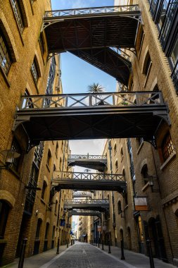 Londra, İngiltere 'den Shad Thames. Londra 'da Tower Bridge yakınlarındaki tarihi Shad Thames. Bu eski kaldırımlı cadde yukarıdaki kaldırımlarıyla ünlüdür. Shad Thames Köprüleri, Bermondsey, Londra, İngiltere.
