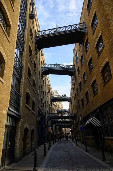 Londra, İngiltere 'den Shad Thames. Londra 'da Tower Bridge yakınlarındaki tarihi Shad Thames. Bu eski kaldırımlı cadde yukarıdaki kaldırımlarıyla ünlüdür. Shad Thames Köprüleri, Bermondsey, Londra, İngiltere.