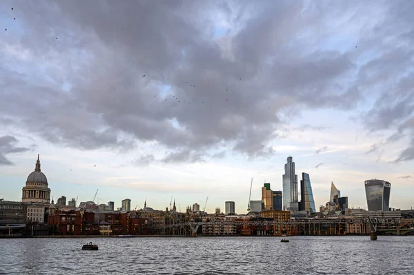 İngiltere 'deki Londra şehri. Thames nehri üzerinden Londra 'ya ve St. Paul Katedrali' ne bakın. Londra, İngiltere 'de gökdelenleri, katedrali ve bulutları olan şehir manzarası 2020.