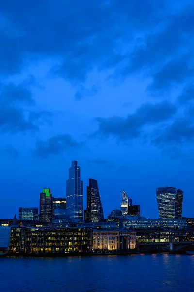 イギリスのロンドン市 夕方にはロンドン市内へのテムズ川をご覧ください 高層ビル ライト 川と夜に雲と青空とCbdの街の風景 ロンドン イギリス2020年 — ストック写真