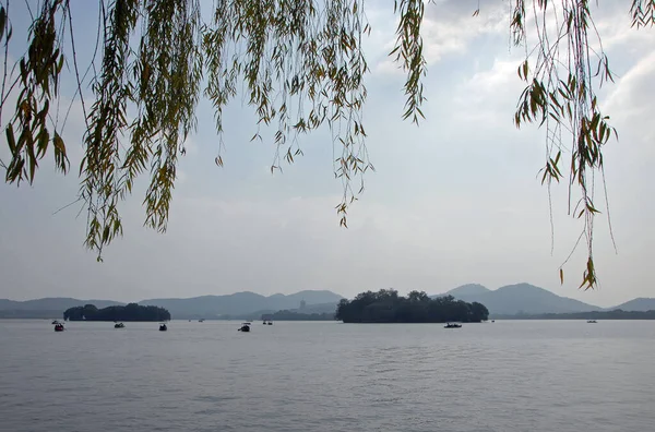 West Lake (Xi Hu) in Hangzhou, Zhejiang Province, China. View beneath a willow tree towards Leifeng Pagoda from Gushan Hill on the north shore of West Lake. West Lake is a tourist sight in Hangzhou.