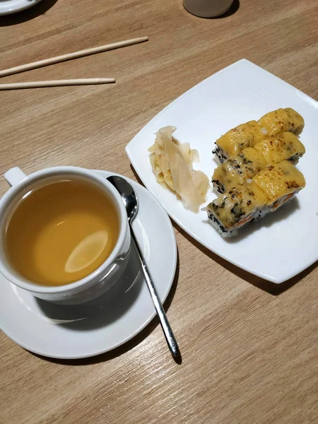 Ekmekli beyaz bardakta çay. Tahta bir masada..