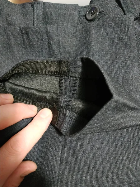 Pantolon ve bir el. Gri kumaş.