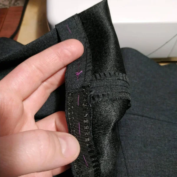 Pantolon ve bir el. Gri kumaş.