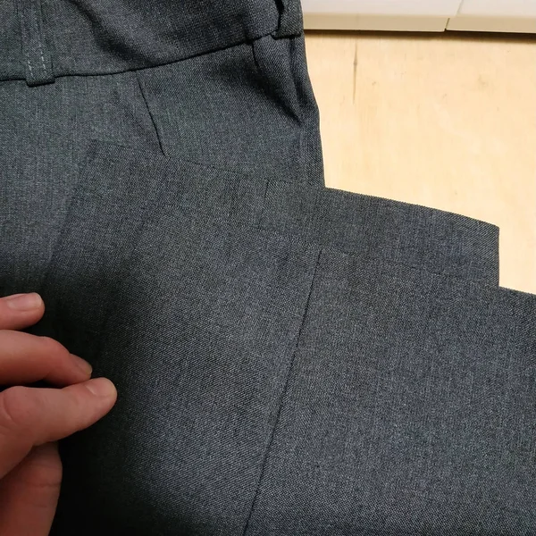 Pantolon ve bir el. Gri kumaş.