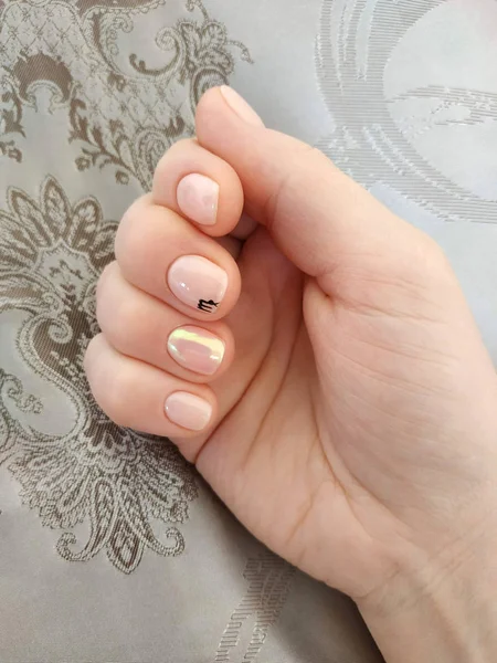 Manikürlü bir kadın eli. İnci kokulu oje..