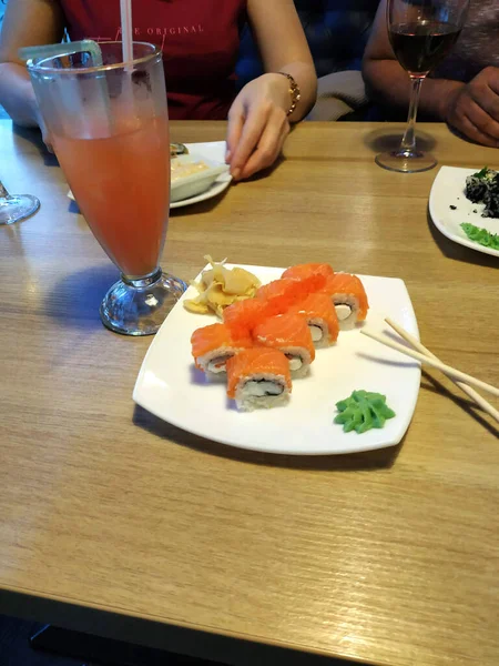 Bir bardak kokteyl ile yuvarlanıyor. Tahta bir masada..