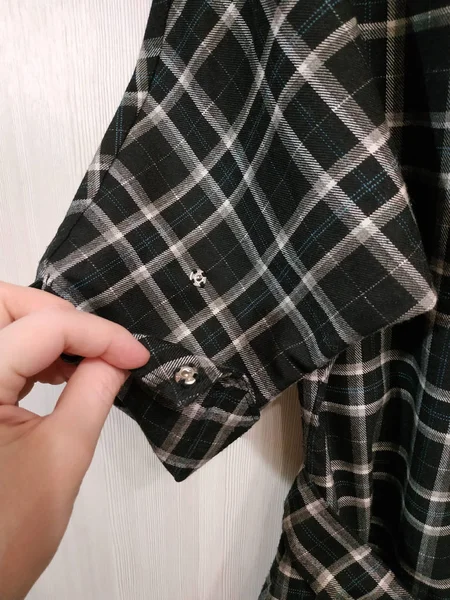 Eli olan bir elbisenin ayrıntıları. Damalı kumaş.