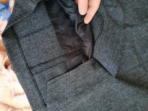 Gri kumaştan yapılmış giysiler. Yatak örtüsünün üzerinde yatarken.