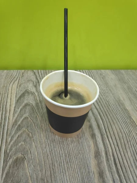 Kâğıt bardakta kahve. Tahta bir masada..