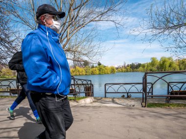 Bükreş / Romanya - 03.17.2020: Kendini Coronavirus 'tan korumak için maske takan adam.
