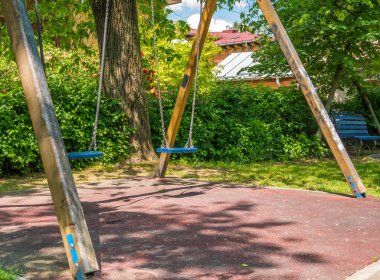 Romanya 'nın Bükreş kentinde bir çocuk parkı. Çocuklar ağaçlarla dolu bir parkta sallanıyor..