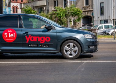 Bükreş / Romanya - 05.16.2020: Yango logosu ve mavi boyalı bir arabaya asgari fiyat yazıldı. Yango, Bükreş sokaklarında at binme ya da selamlama hizmeti veriyor.
