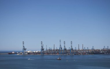 Tersanede çalışan vinç köprüsü olan konteyner kargo gemisi ve kargo uçağının lojistik ve taşımacılığı. Uzaktan bakıldığında.