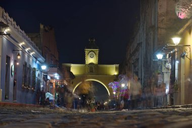 Guatemala 'daki El Arco Sokak ışıklarıyla aydınlatılmış Sokakta yürüyen insanlar.